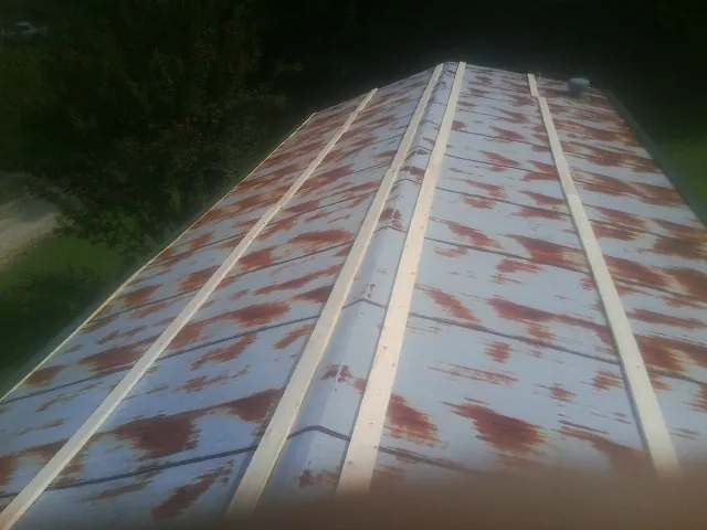 Rusted metal roof panels with new wood purlins before replacement — Storm Damage Roof Repair in Branchdale by Roofing Brothers