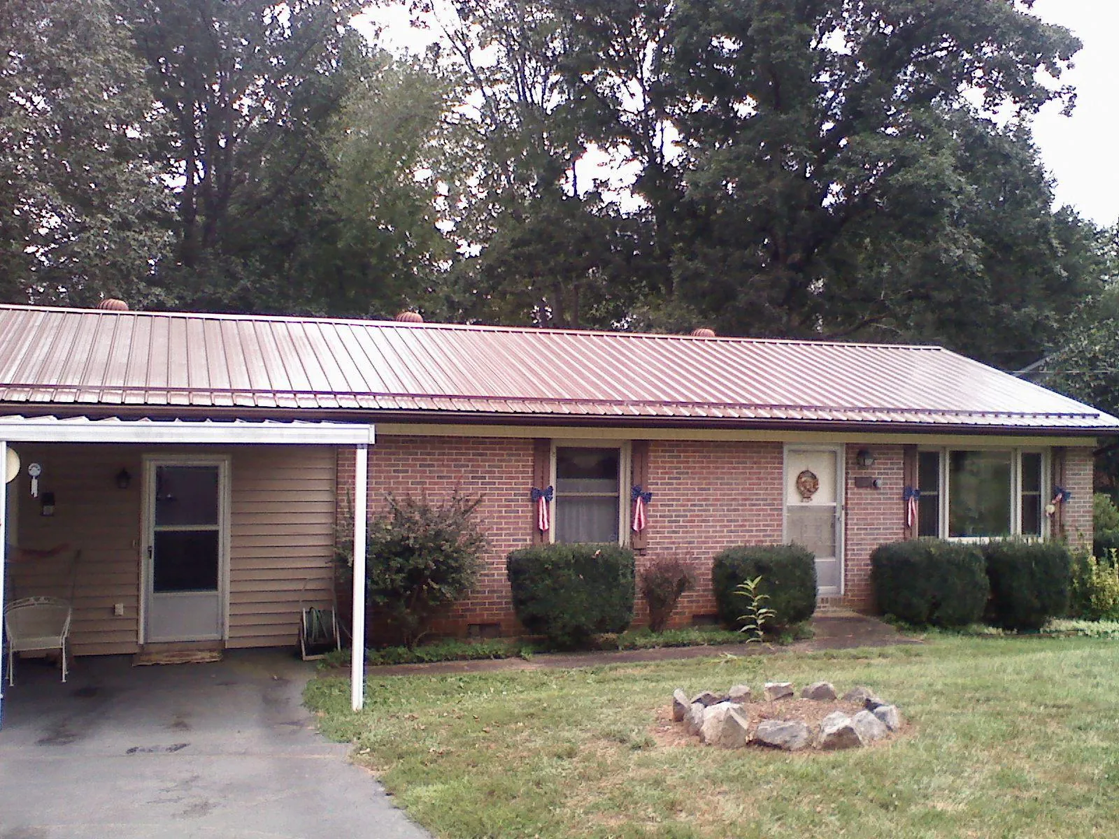 Bronze metal roof and carport on a brick ranch home — Roof Repair work by our crew in Branchdale